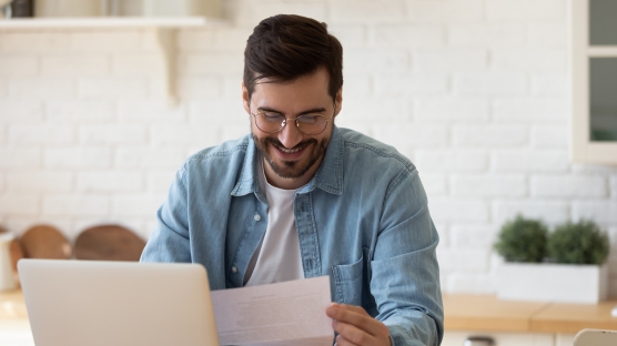 Person-Reading-Paper-Laptop-556x312