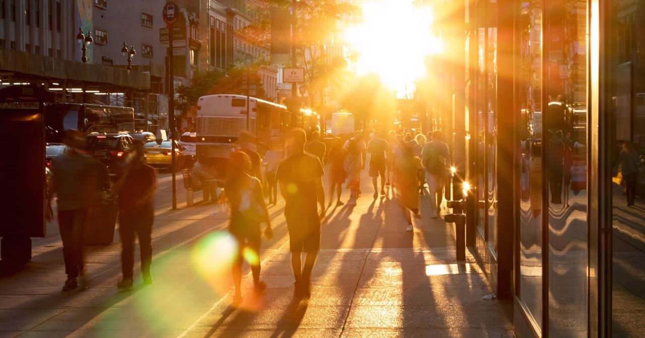 personas en la calle caminando con la puesta de sol