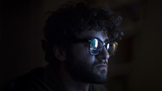 Man looking at code in the dark