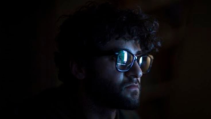 Man looking at code in the dark