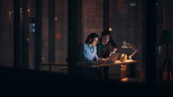 two-colleagues-working-at-night-in-the-office