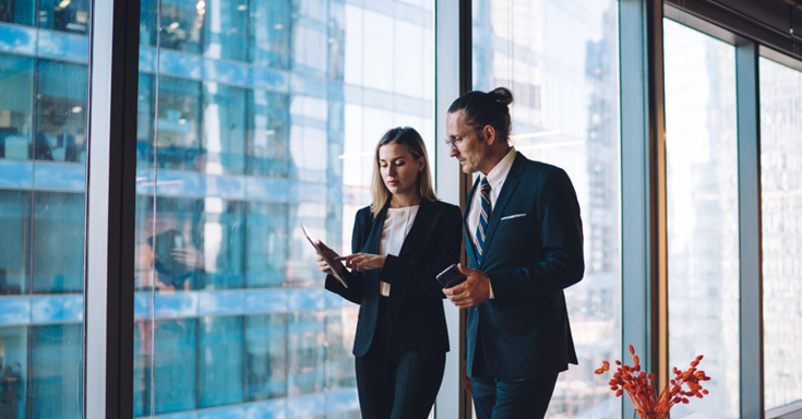 two people walking through the office