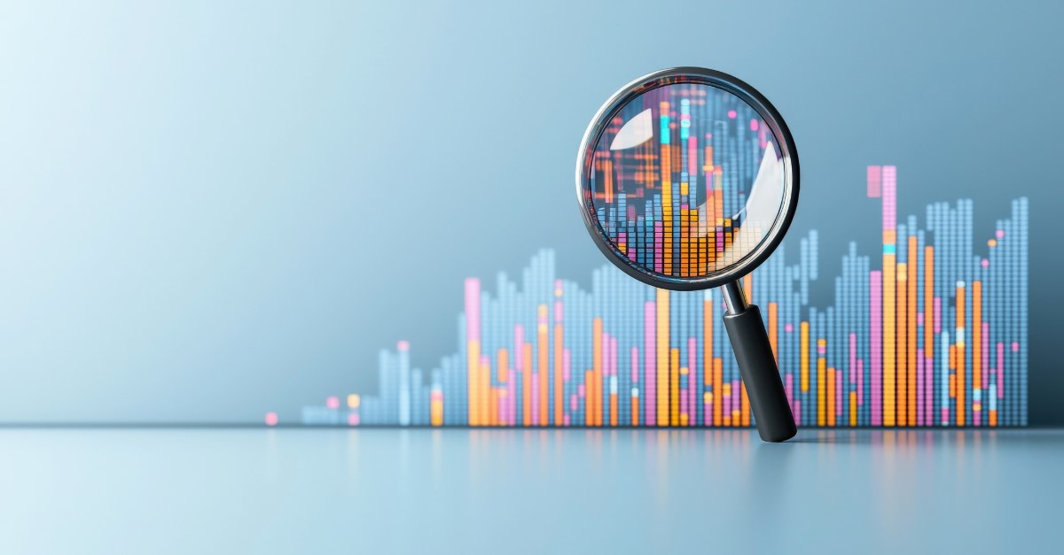 A magnifying glass standing up in front of a bar chart