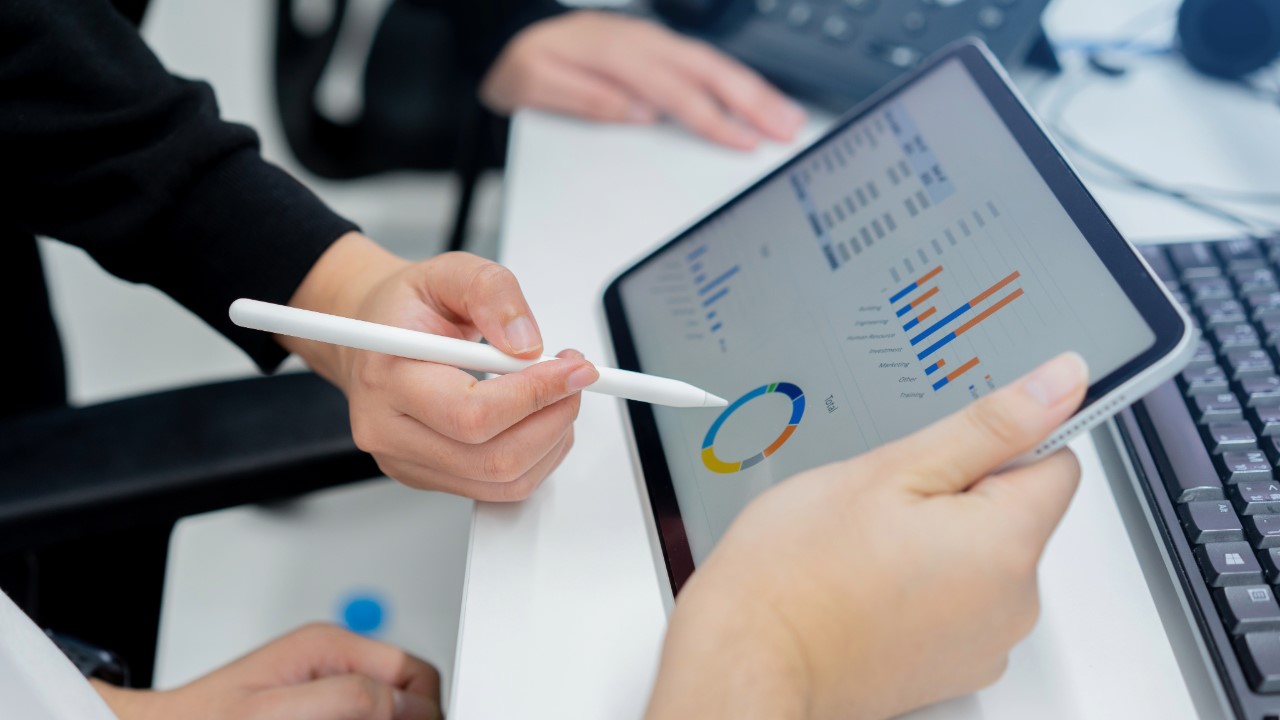 Two people review figures on a tablet