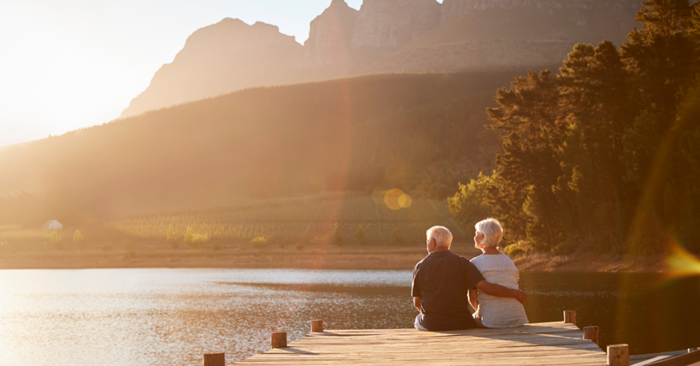 Two retired people sitting at a pier