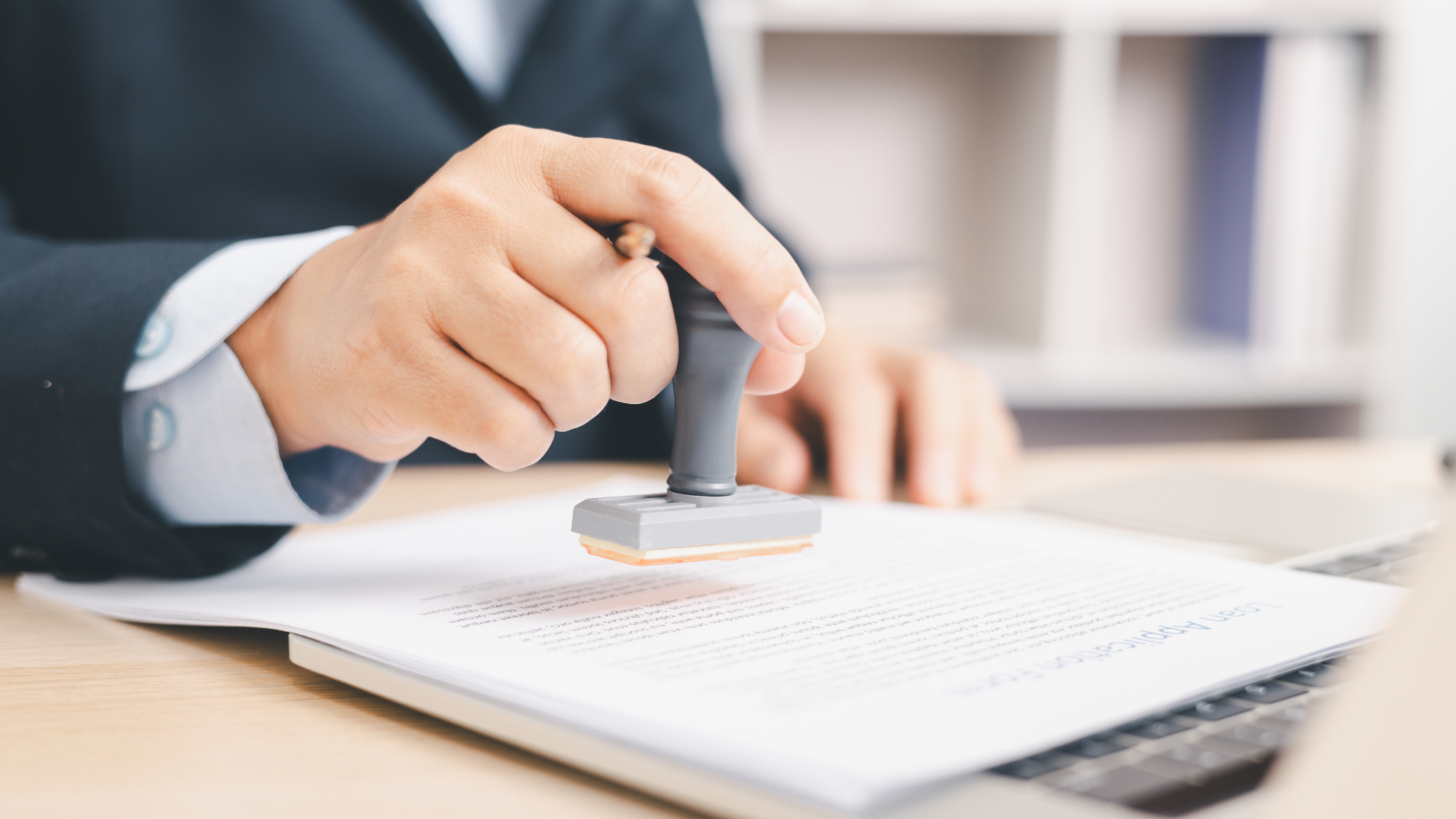 Businessman signing and stamping official document at desk, concept of legal contract approval, authorization or business agreement confirmation in corporate office background. stamp approval