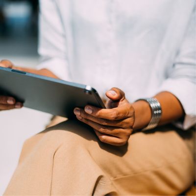 Person sitting down holding a tablet