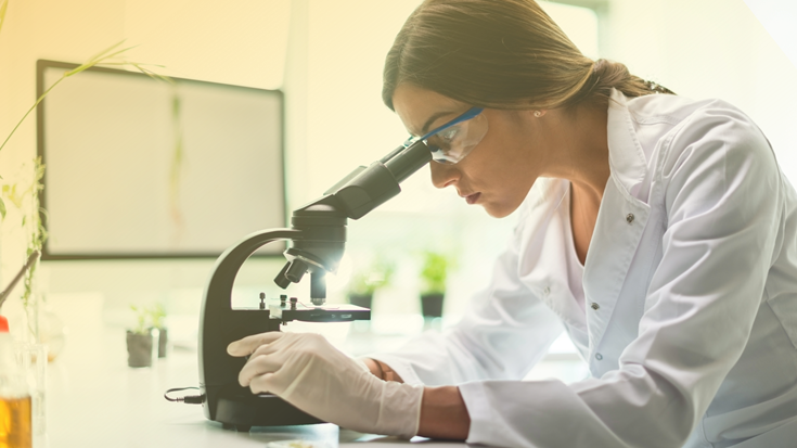 A woman looking through a microscope