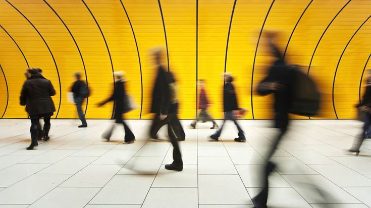 Blurred people walking through tunnel yellow