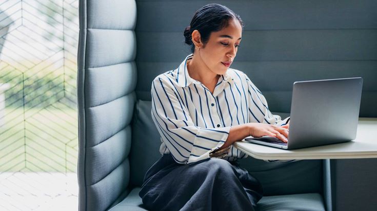 business-woman-working-on-laptop-in-a-booth