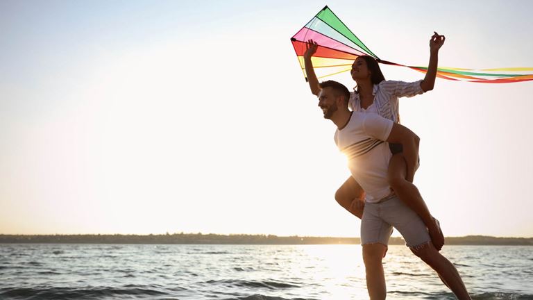couple on beach with kite
