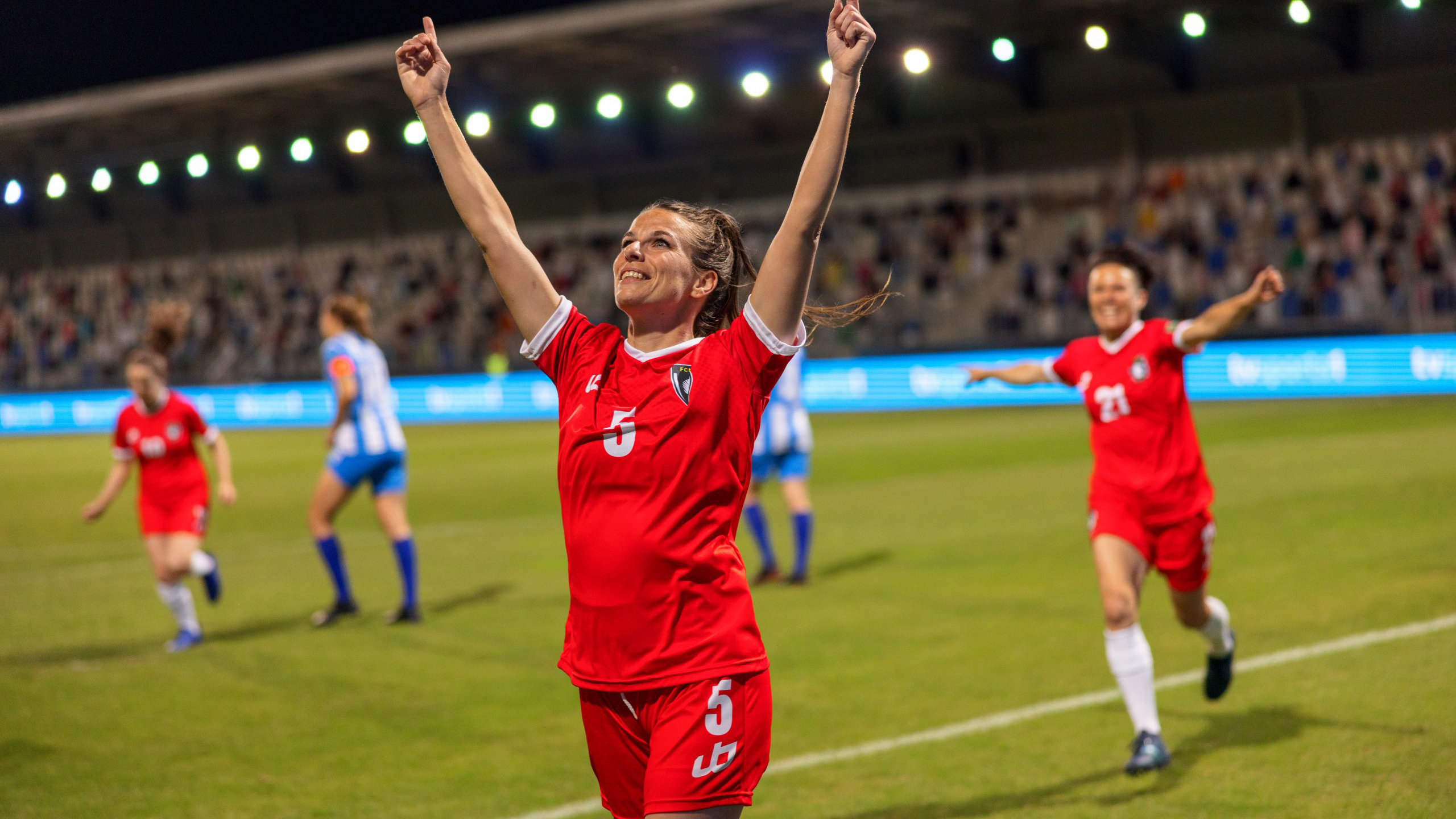 female football player on pitch celebrating