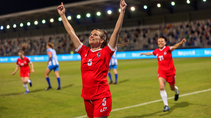 female football player on pitch celebrating