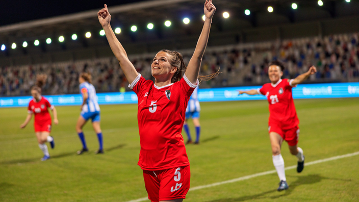 female football player on pitch celebrating