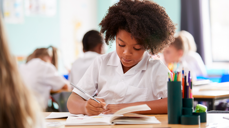 girl writing on textbook