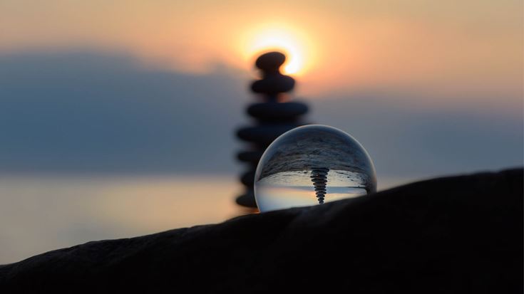 globe and pebbles on beach