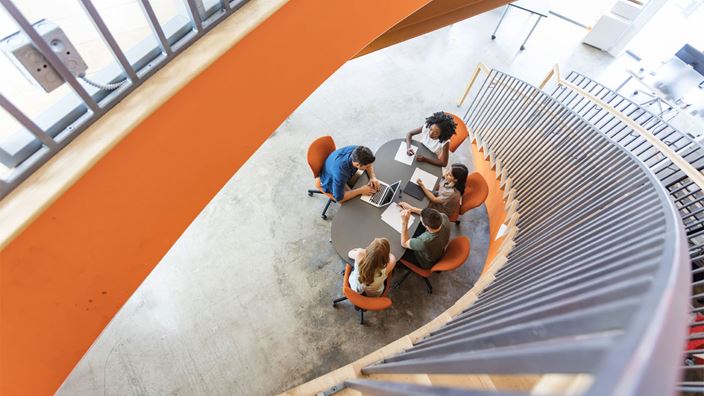 Group of people meeting at bottom of staircase