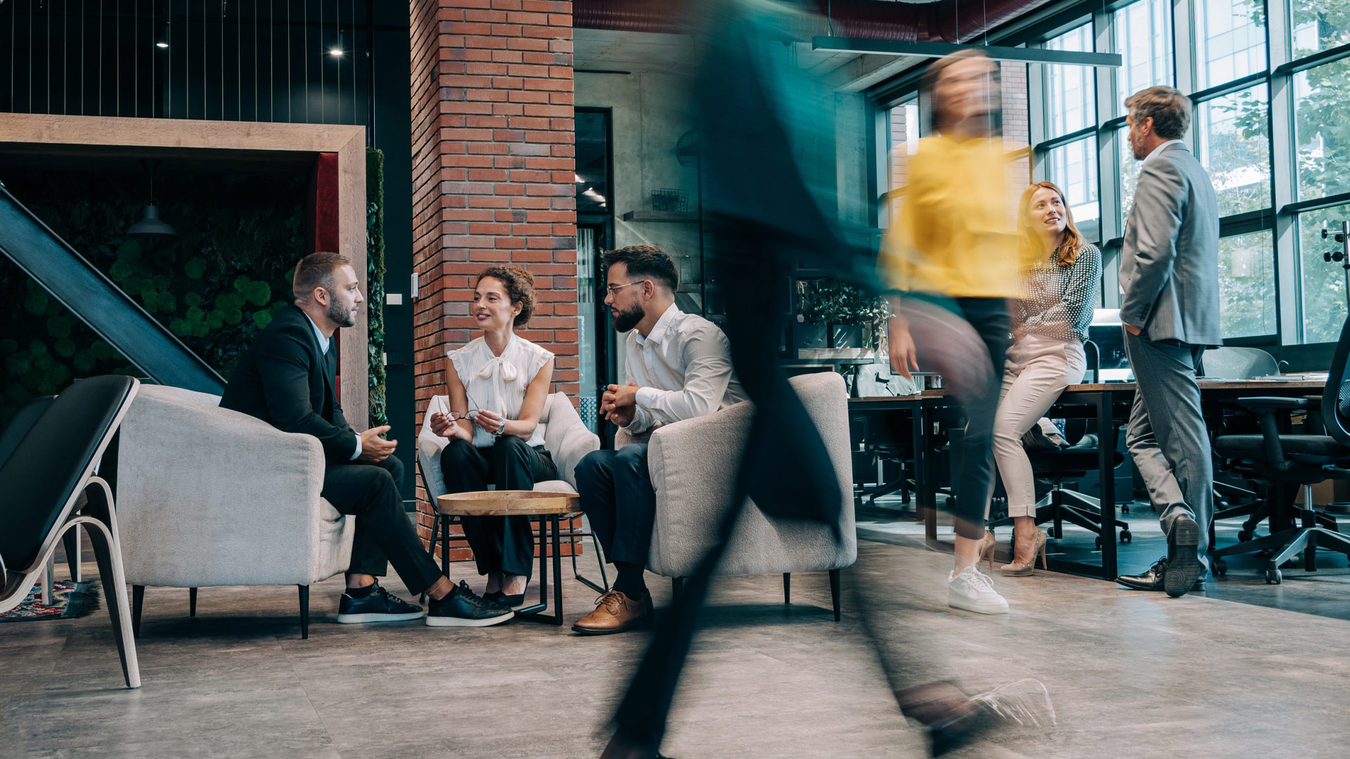 group of people sitting in office with people rushing