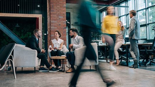 group of people sitting in office with people rushing