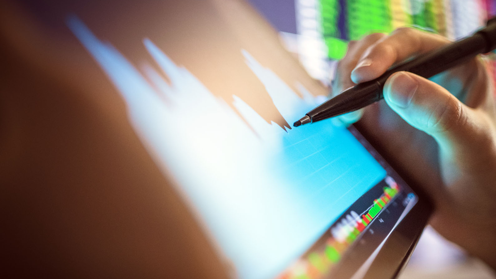 hand on tablet looking at stock exchange