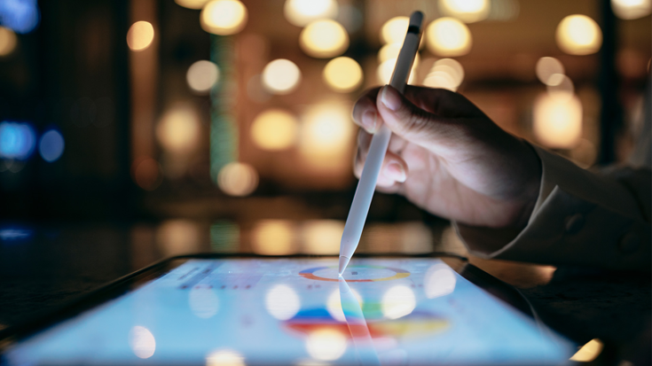 ipad and pen with graphs