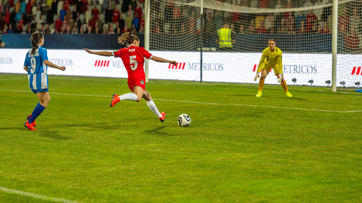 Lady football scoring a goal