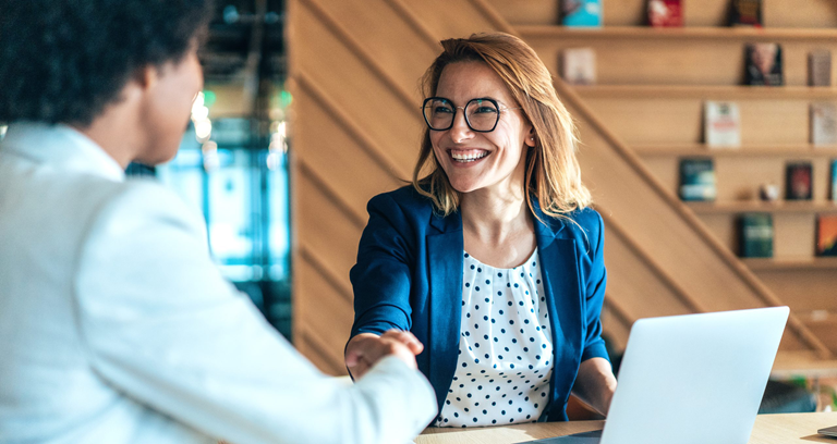Lady shaking hands at a desk