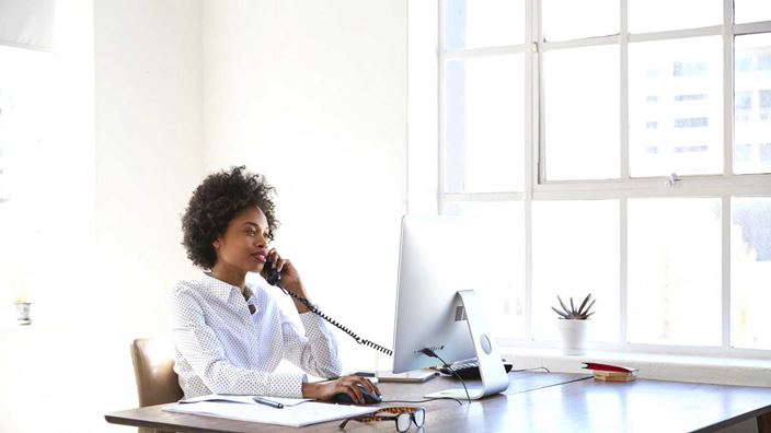 lady-working-at-desk-on-phone