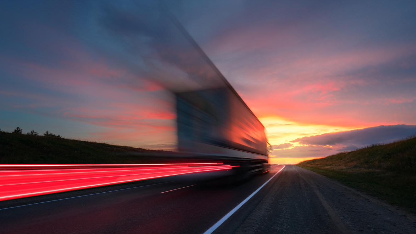 lorry driving on road at dusk