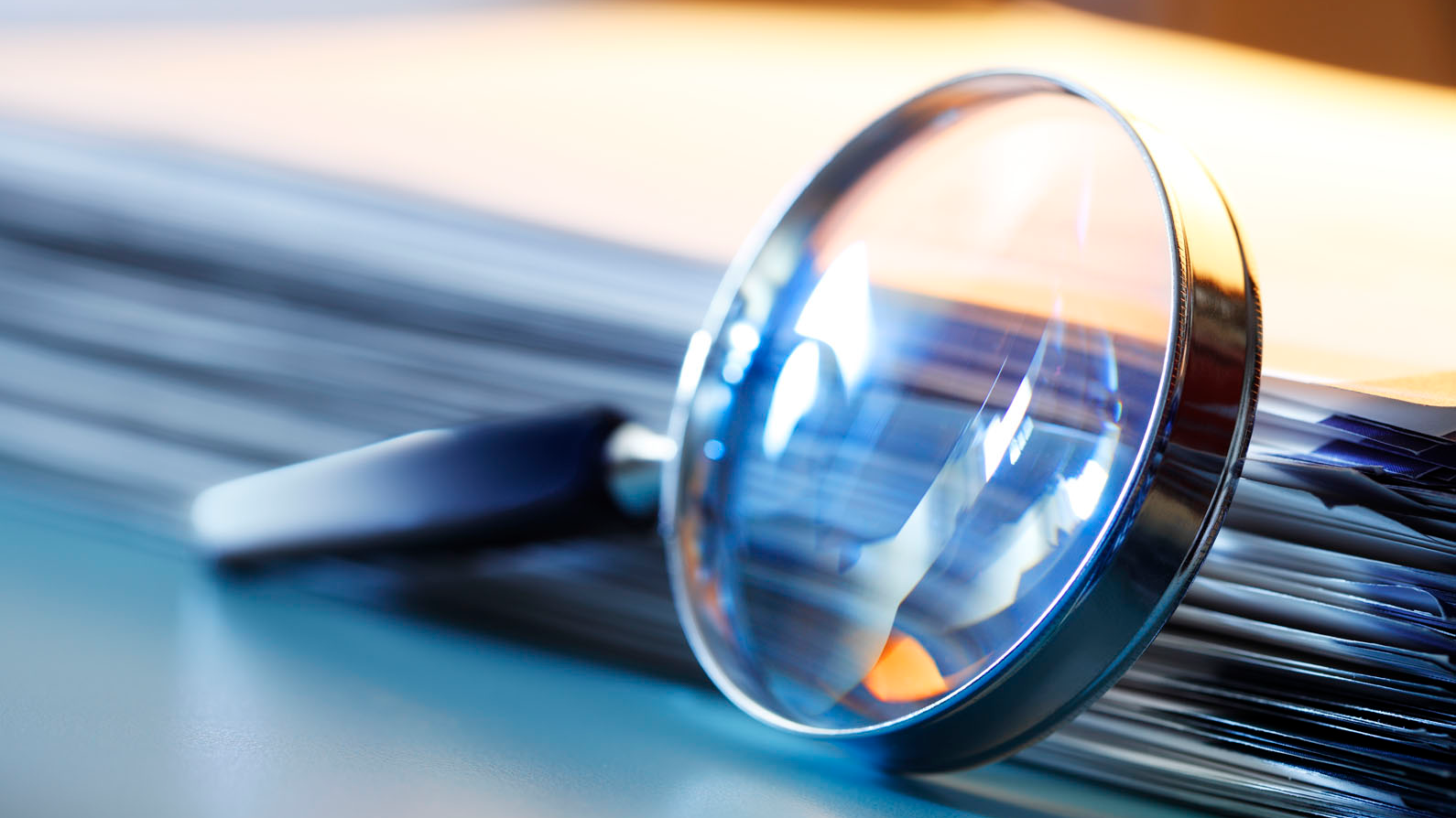 magnify glass leaning against documents