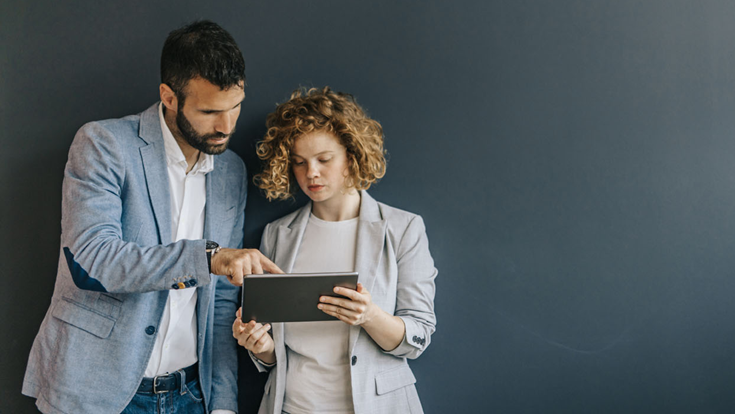 man and woman looking at a tablet