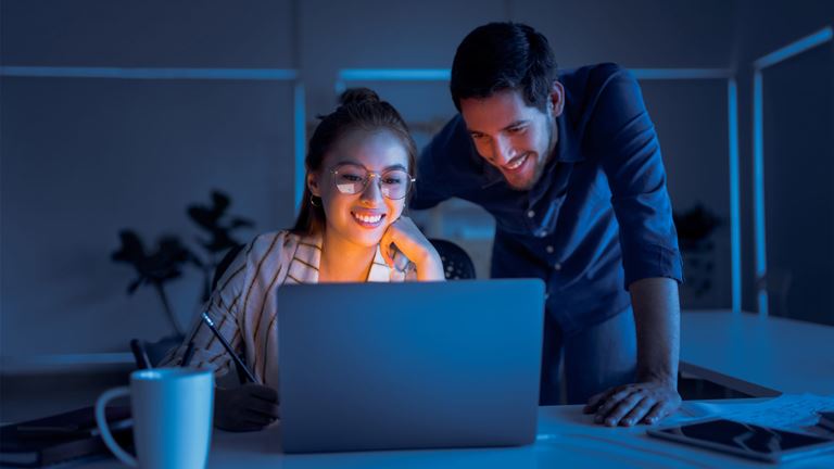 Man and Woman smiling at laptop screen