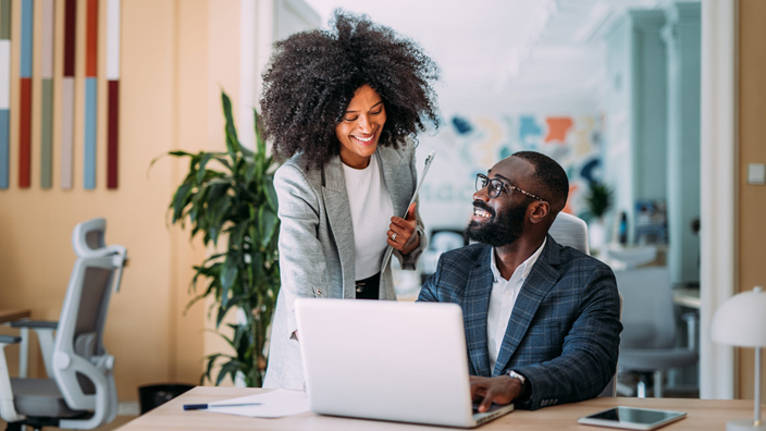 man and woman working together on a laptop