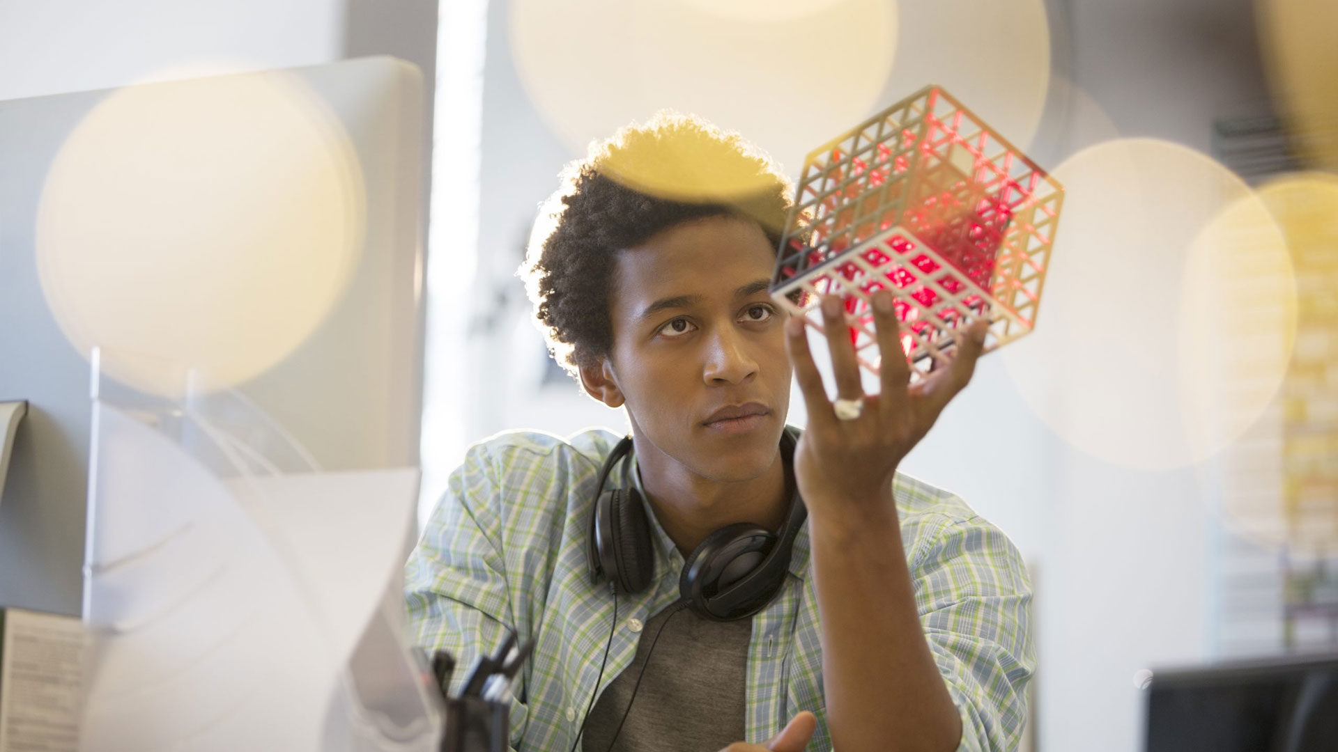 man examining cube at desk in office