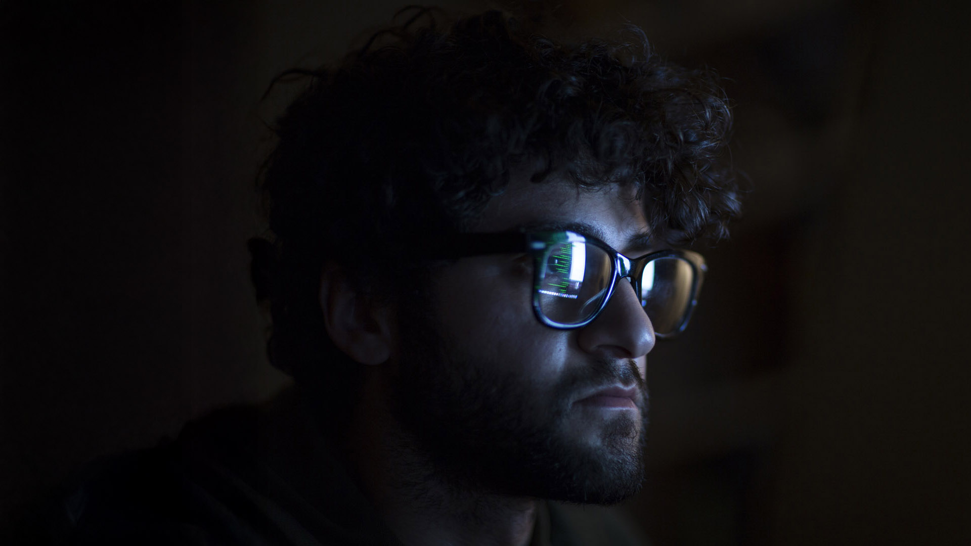 Man looking at code in the dark