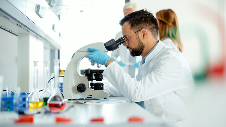 man looking through a microscope