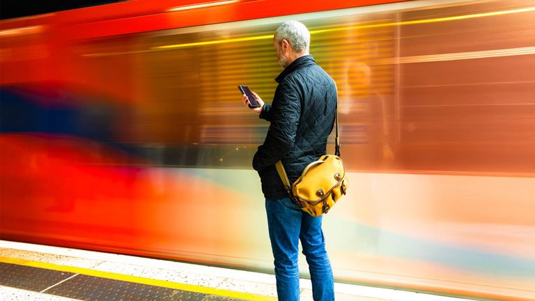 Man on phone with blurred train