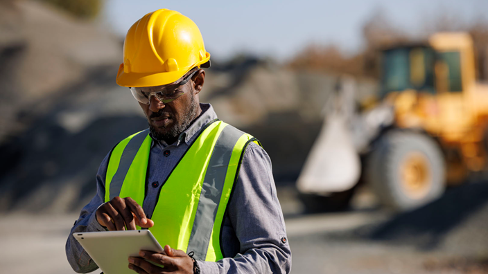man on tablet at a construction site