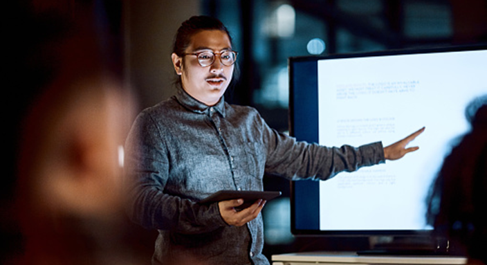 man presenting on tablet and screen