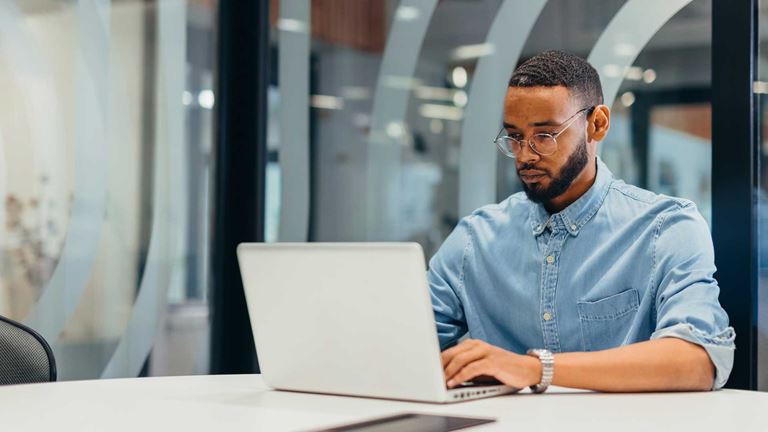 Man-typing-at-desk