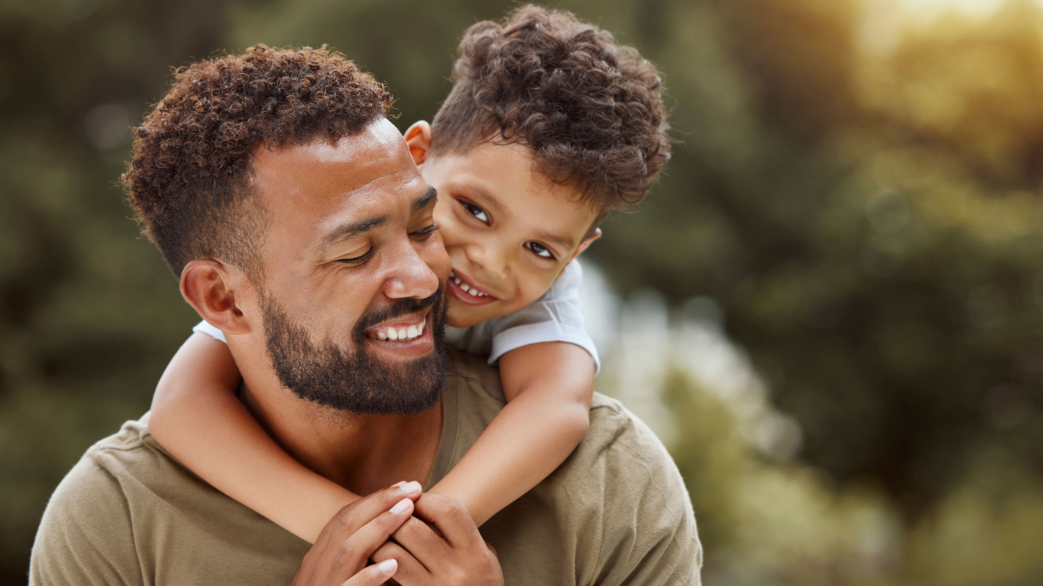 A man with child hugging his neck
