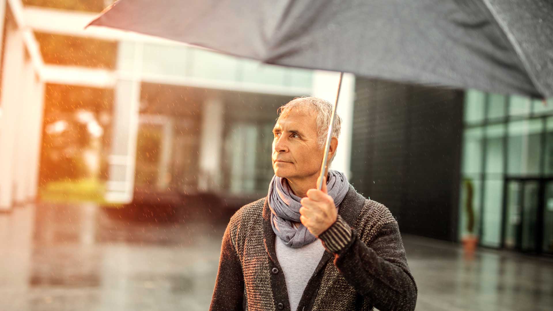 Older man under umbrella