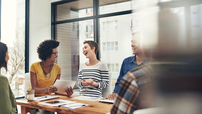 people in collaborative meeting smiling