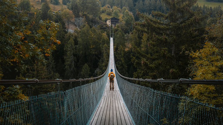 Person walking across rope bridge