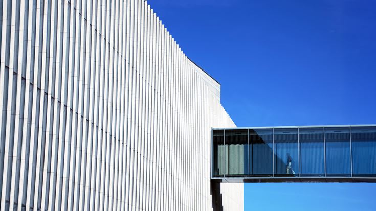 Person walking in to building through bridge
