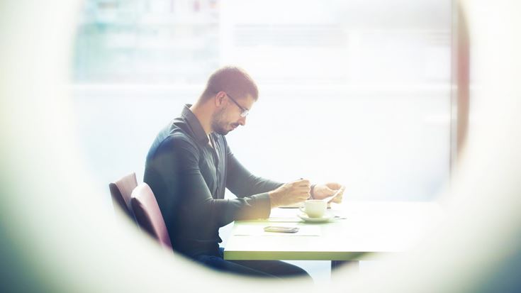person with coffee and paper