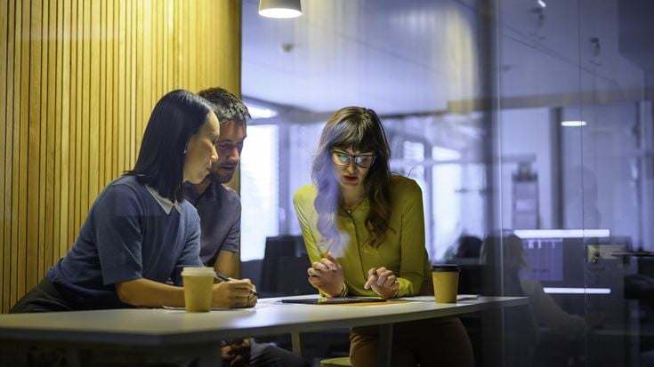 three people in glass meeting room