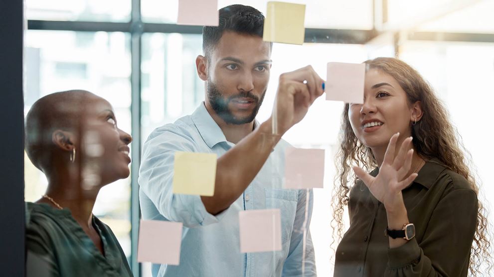 Three people working on post it notes