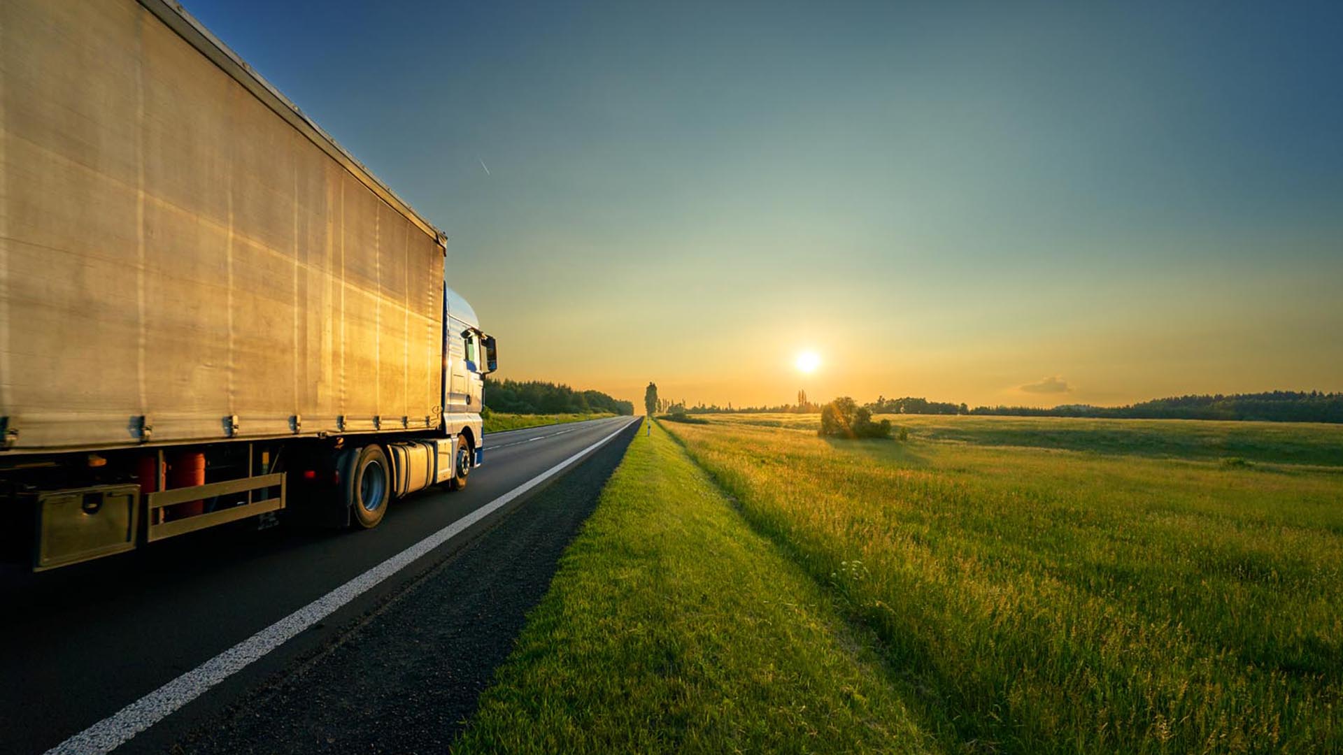 Truck driving into sunset