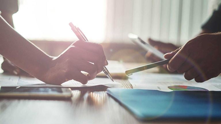 Two business people reviewing and signing documents